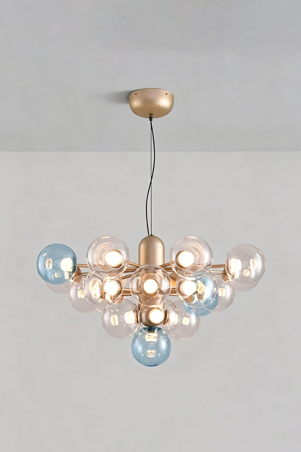 Astraea Prismatic Globe Chandelier | Glass, Metal | Studio view of the ocean blue glass bubble variant fully illuminated against a plain grey backdrop | vexa lamps
