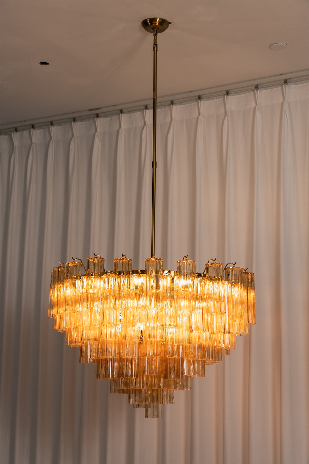 Isadora Tiered Amber Glass Chandelier with amber glass prisms hanging elegantly from a metallic downrod.