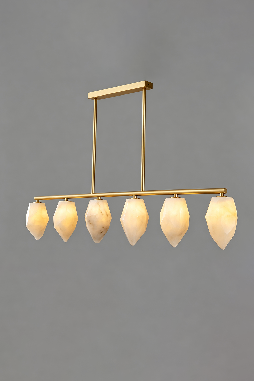 Manon Alabaster Drop Linear Chandelier | Natural Alabaster and Brass | Full front view glowing softly against a solid grey background | vexa lamps