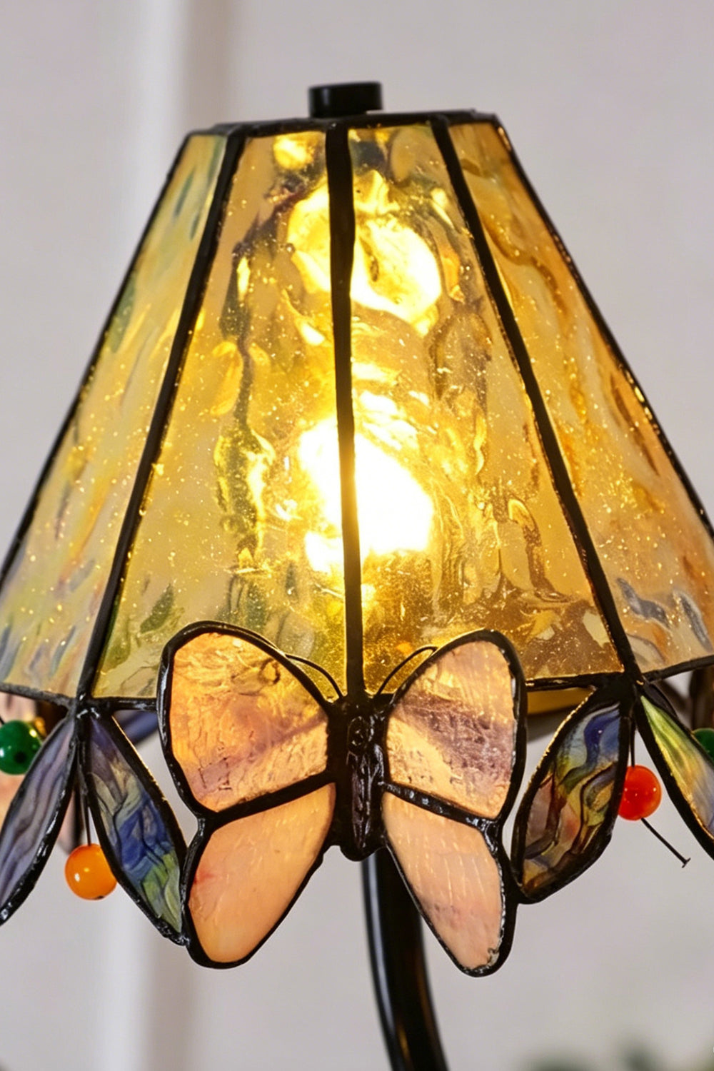 Seraphina Stained Glass Chandelier | Glass, Metal | Extreme close-up of a single lit conical Tiffany shade radiating a warm yellow glow through the textured glass | Detail shot | vexa lamps