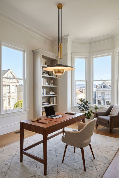 Adelaide Saucer Brass Pendant Light illuminating a stylish home office with a wooden desk and modern decor.