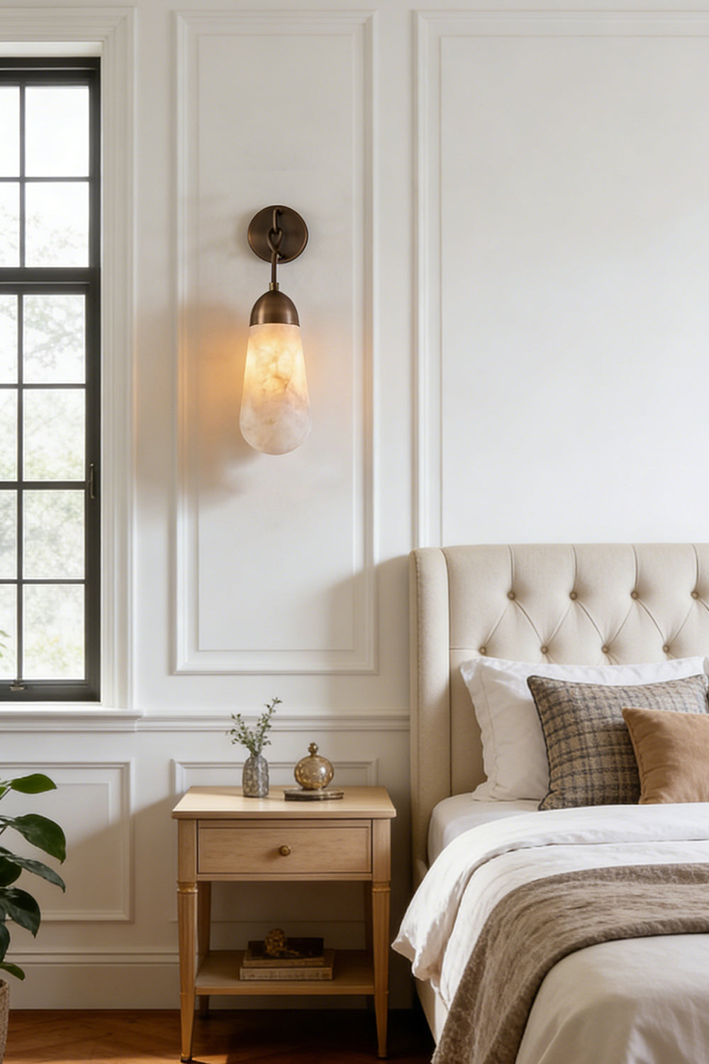 Alabaster Teardrop Wall Sconce illuminating a stylish bedroom with a tufted headboard and elegant nightstand.