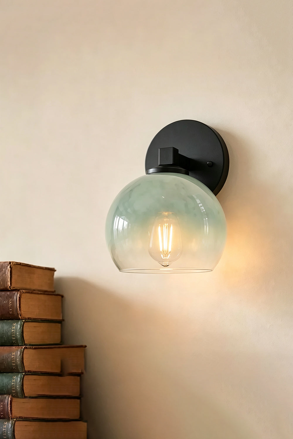 Alba Ombre Glass Wall Sconce featuring hand-blown green glass globe and iron bar, ideal for bathroom or entryway.