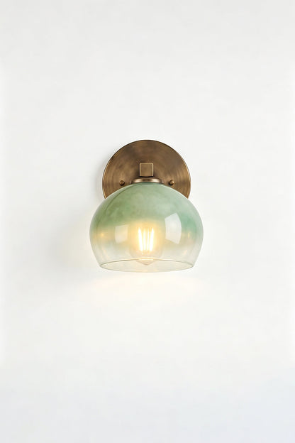 Alba Ombre Glass Wall Sconce with green glass globe and brass backplate, ideal for bathroom or entryway lighting.