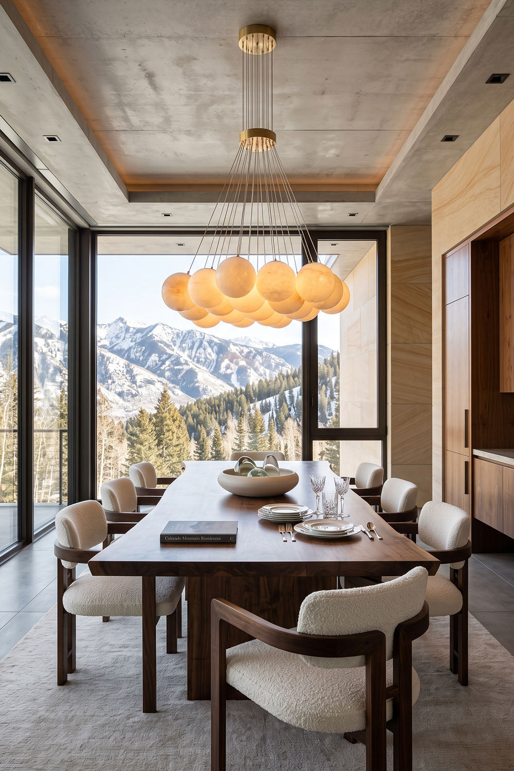 Amandine Alabaster Globe Cluster Pendant Light illuminating a stylish dining room with mountain views.