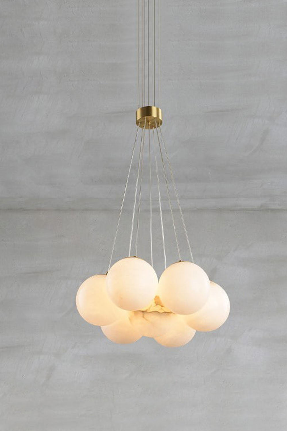 Amandine Alabaster Globe Cluster Pendant Light hanging above a gray background, showcasing its elegant alabaster globes.