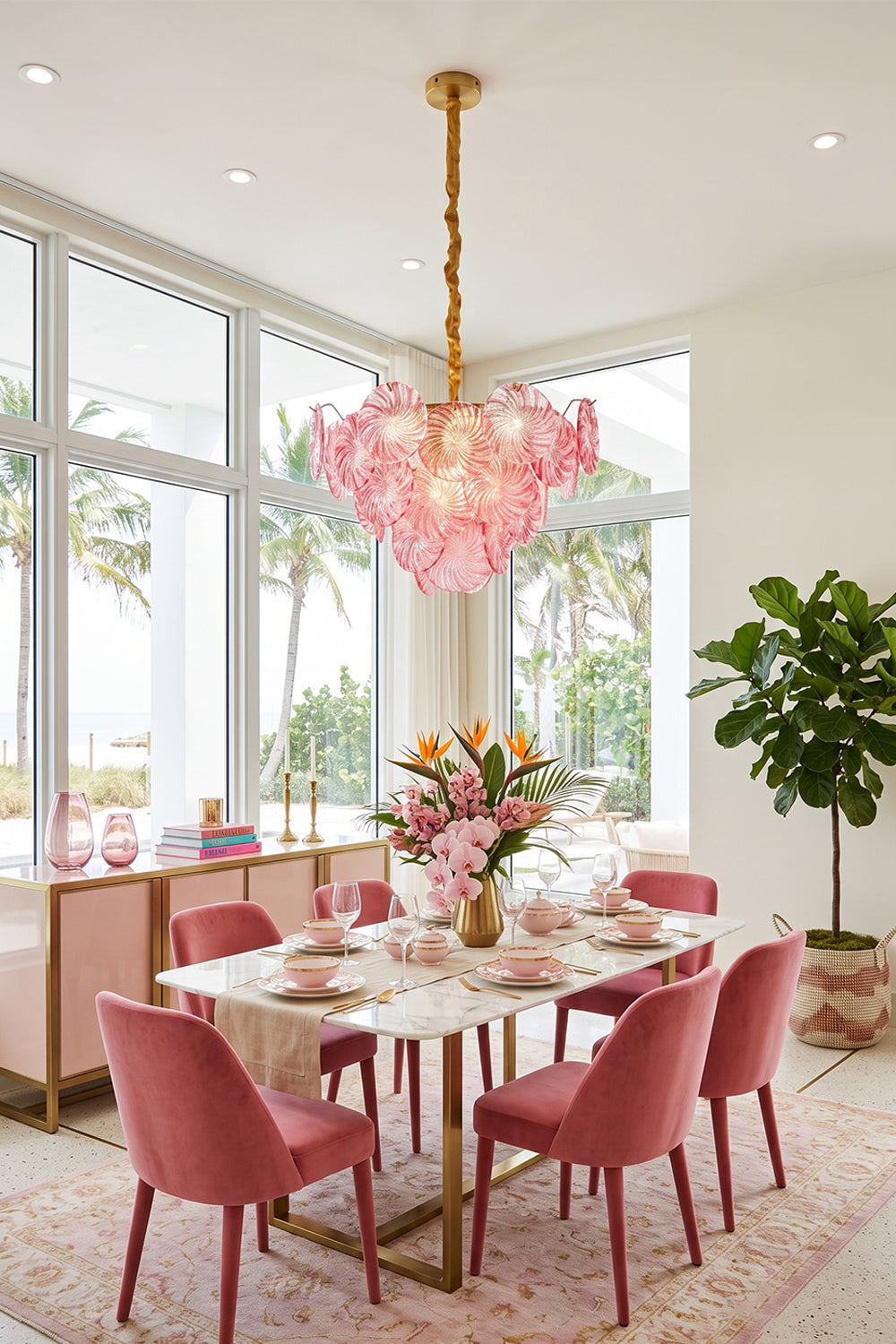 Amara Pink Glass Petal Chandelier | Pink Dining Room | The pink glass petal fixture serving as a stunning centerpiece above a dining table surrounded by plush pink velvet chairs | vexa lamps