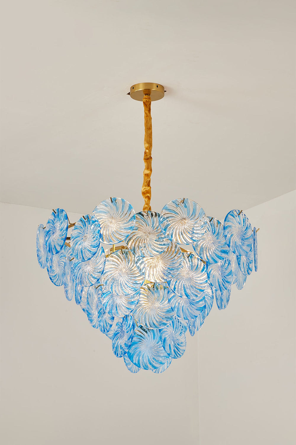 Amara Pink Glass Petal Chandelier | Blue Studio View | Studio presentation of the fully illuminated sea-blue glass petal variation casting a vibrant glow against a plain wall | vexa lamps