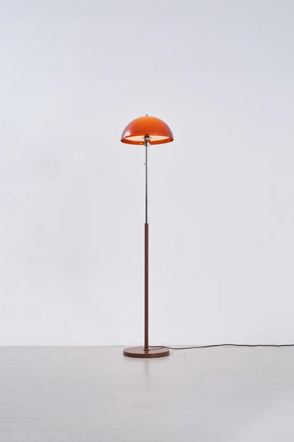 Ambrose Amber Dome Floor Lamp | Amber Glass, Metal and Wood | Full standing view glowing in a studio setting with soft backdrop | vexa lamps