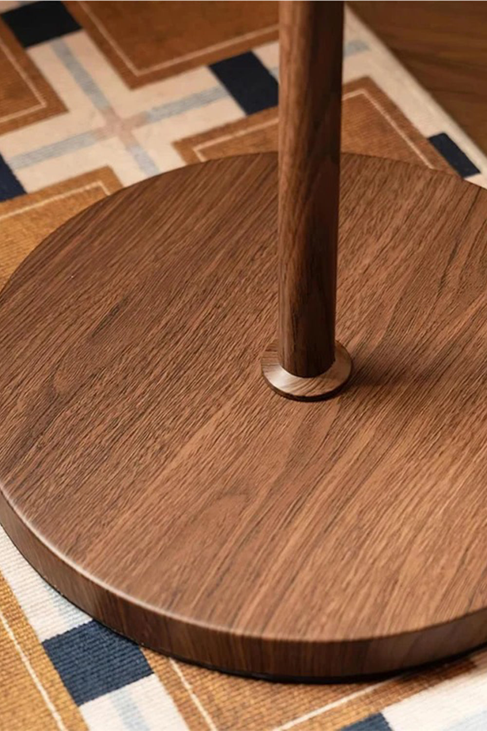 Ambrose Amber Dome Floor Lamp | Amber Glass, Metal and Wood | Detail shot of the smooth circular wood base on a patterned rug | vexa lamps