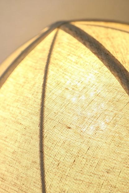 Angolo Canted Faceted Wood Table Lamp | Wood, Fabric, Metal | Macro close-up of the lit fabric lampshade, highlighting the ribbed panels and textured material | Detail shot | vexa lamps