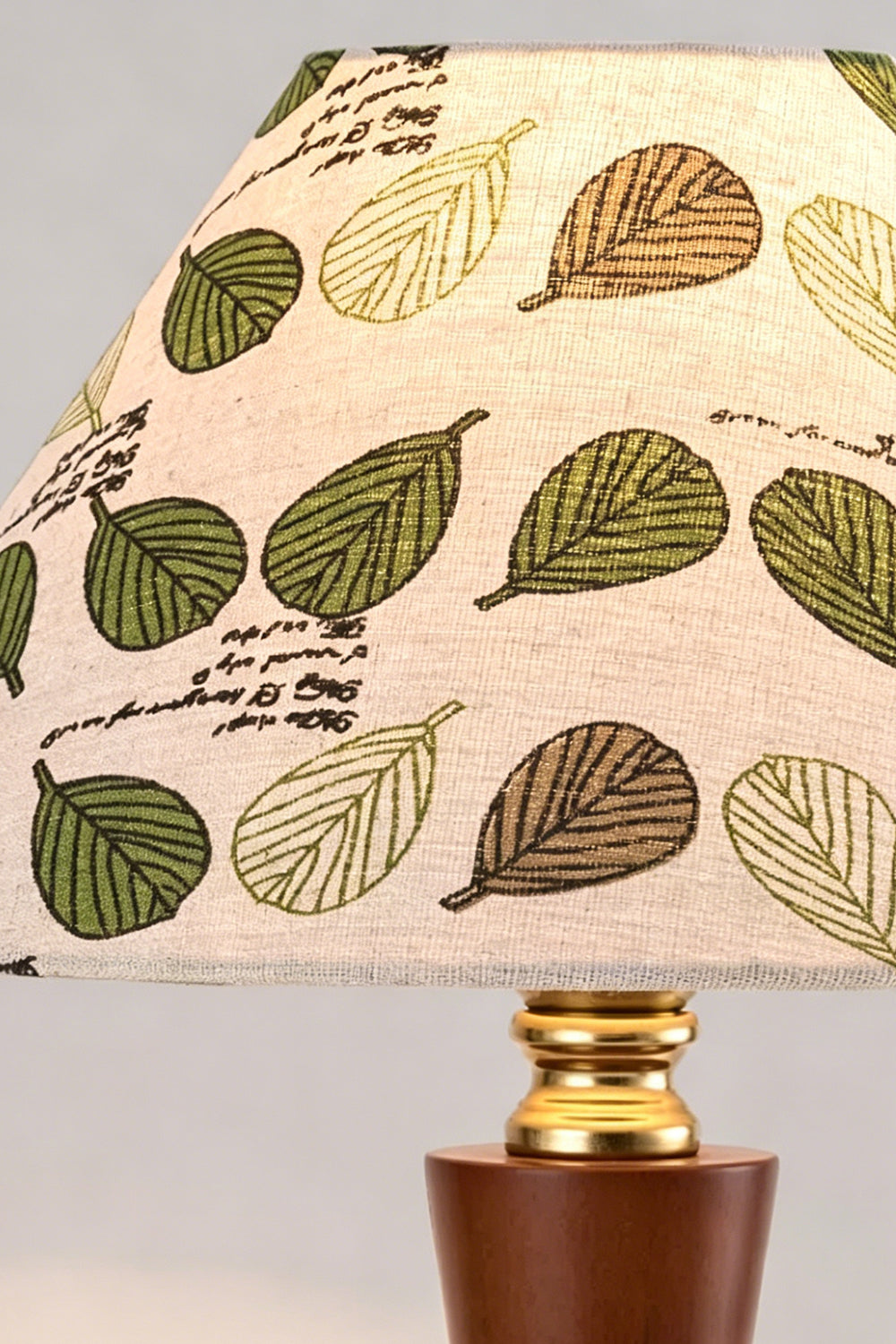 Arboreal Canopy Walnut Table Lamp featuring a fabric shade with leaf patterns in green and brown tones.