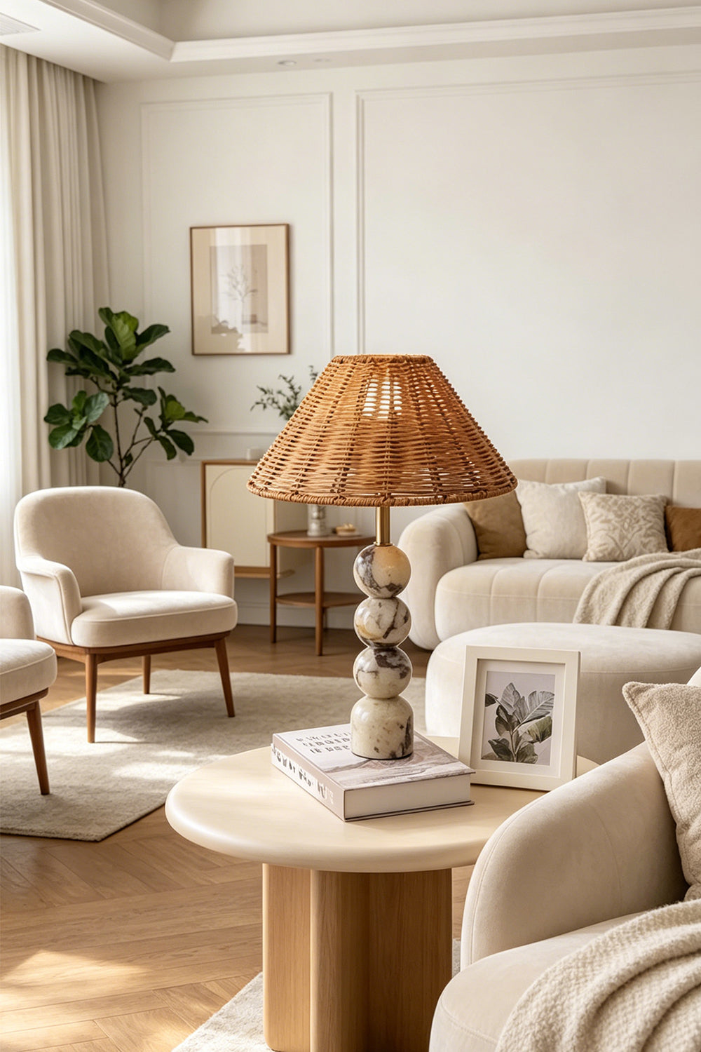 Aria Rattan & Stacked Marble Table Lamp displayed in a cozy living room setting with neutral furnishings.