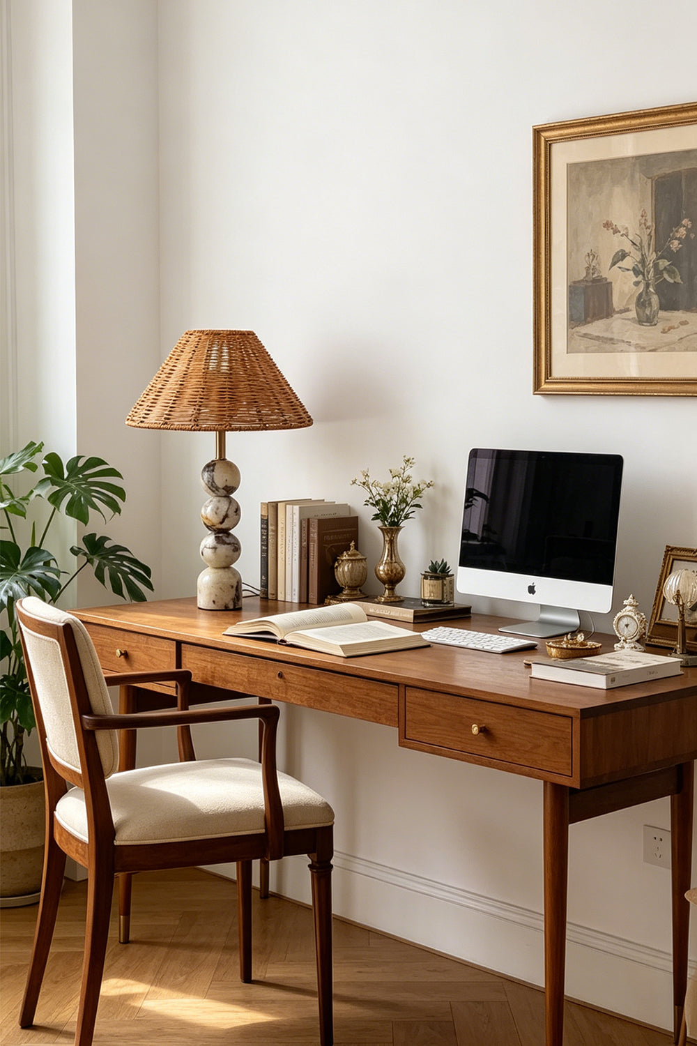 Aria Rattan & Stacked Marble Table Lamp on a wooden desk with a computer and decorative items in a cozy office setting.