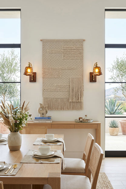 Arlo Amber Ripple Wall Lamp | Glass, Metal, Wood | Flanking a bohemian woven wall hanging above a wooden console table in a bright minimalist dining room | vexa lamps