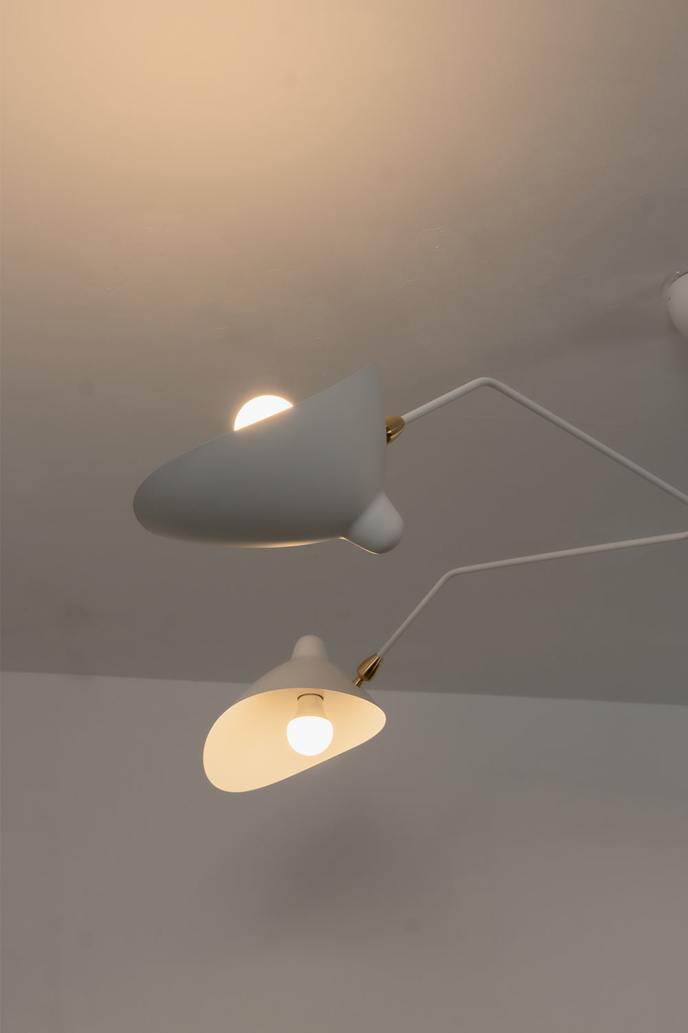 Close-up of lit white articulated lamp shades | Metal | Detail shot showing light diffusion and pivot joints | vexa lamps