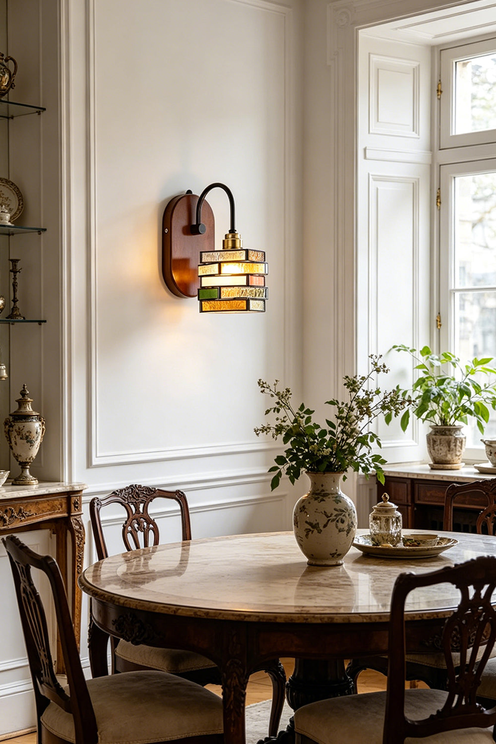 Artisan Mosaic Stained Glass Wall Sconce illuminating a dining area with elegant decor and natural light.