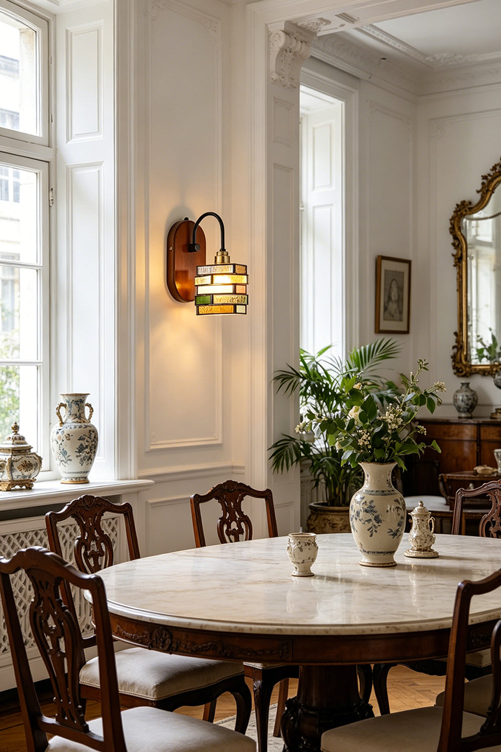Artisan Mosaic Stained Glass Wall Sconce illuminating an elegant dining area with vintage decor and plants.