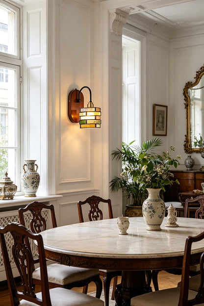 Artisan Mosaic Stained Glass Wall Sconce illuminating an elegant dining area with vintage decor and plants.