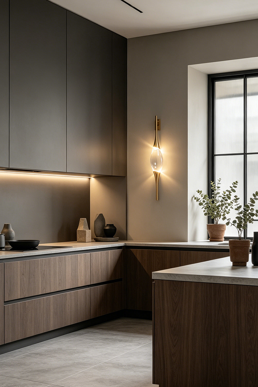 Astraea Crystal Linear Wall Sconce | Crystal, Brass | Installed as a luxury wall accent in a modern kitchen with dark matte cabinetry and a grey backsplash | vexa lamps