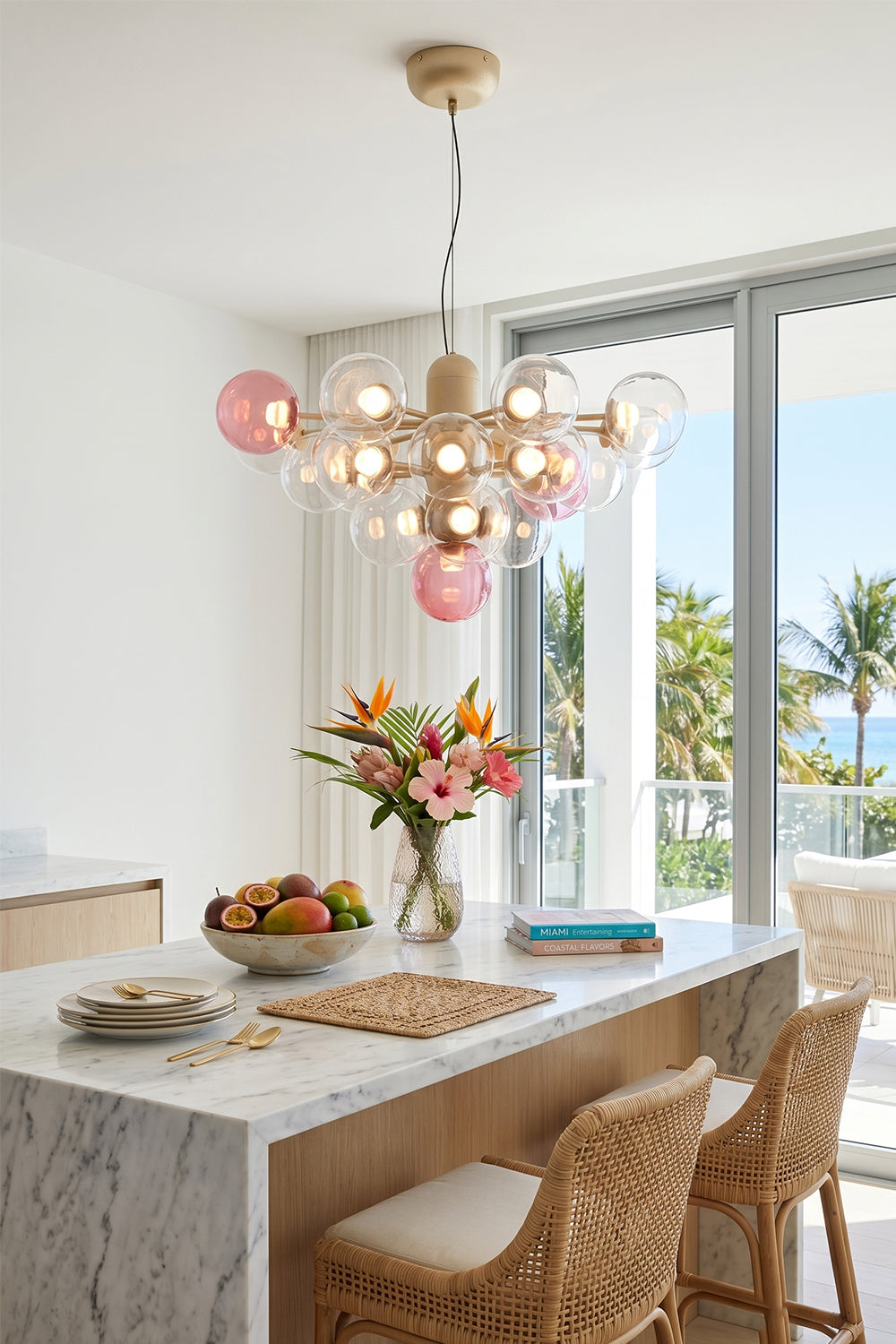 Astraea Prismatic Globe Chandelier | Glass, Metal | Suspended as a playful elegant centerpiece above a pristine white kitchen island counter with woven rattan bar stools in a coastal home | vexa lamps