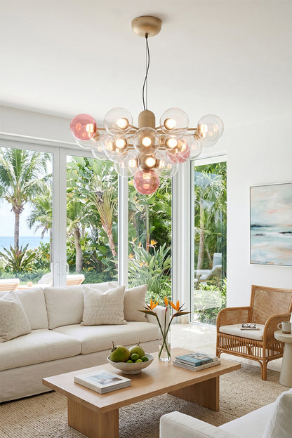 Astraea Prismatic Globe Chandelier | Glass, Metal | Casting a warm ambient glow over a cream fabric sofa and low wood coffee table in a sunlit living room with palm tree views | vexa lamps