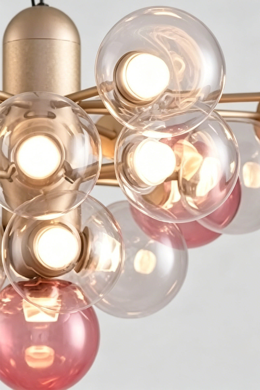 Astraea Prismatic Globe Chandelier | Glass, Metal | Up-close shot highlighting the satin gold metal central housing tube and clustered glass bubbles refracting warm light | Detail shot | vexa lamps