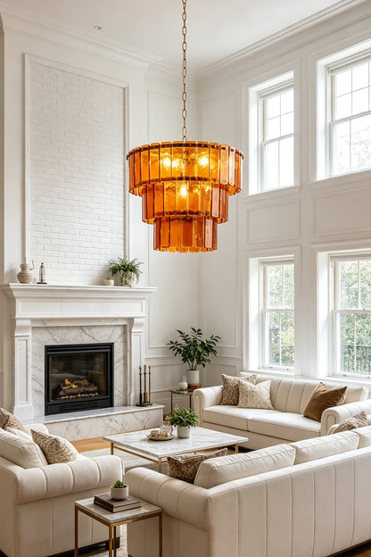 Aurelia Tiered Amber Glass Chandelier illuminating a modern living room with white sofas and a fireplace.