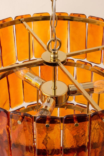 Aurelia Tiered Amber Glass Chandelier featuring golden metal accents and textured amber glass panels.