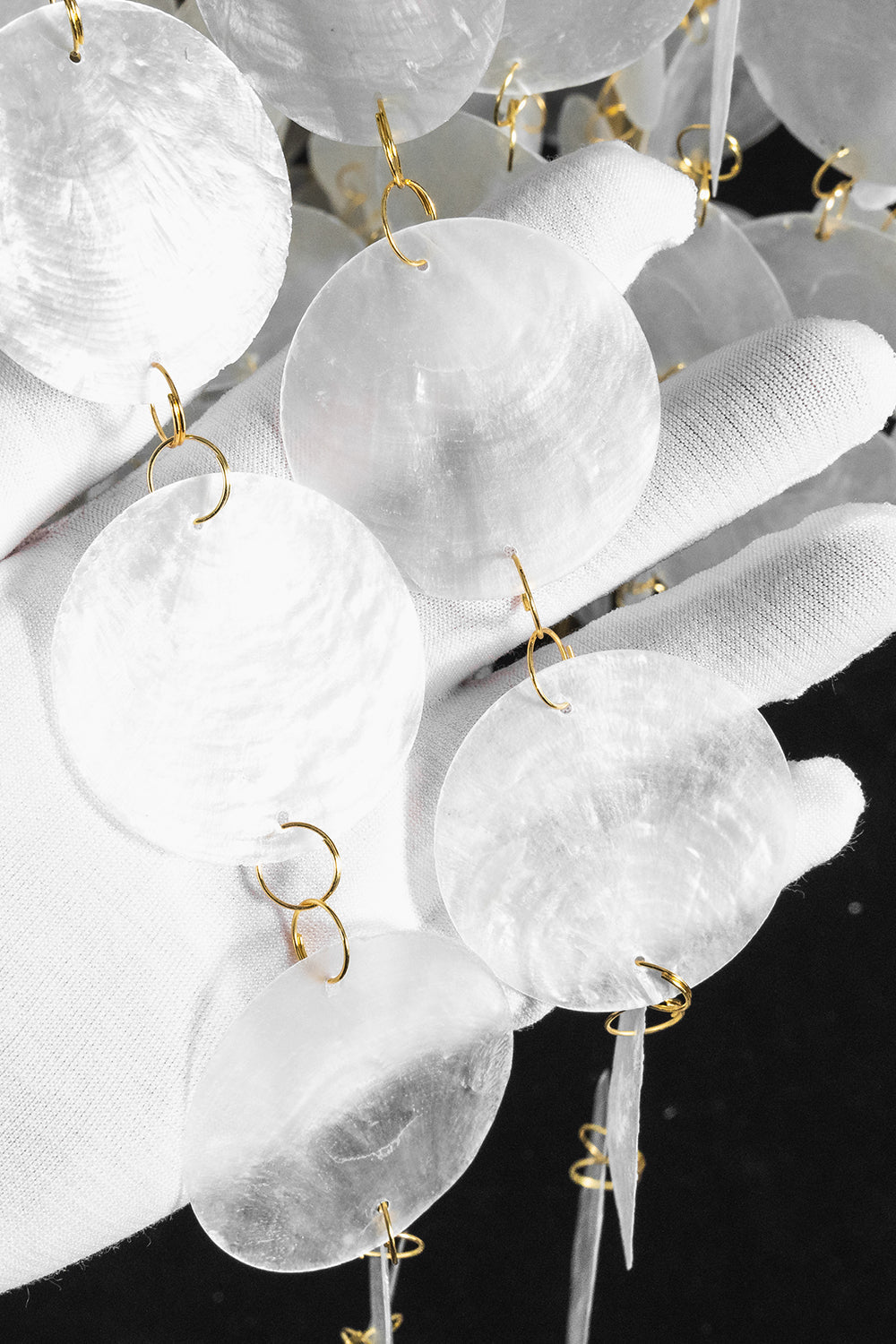 Aurelia Tiered Capiz Table Lamp | Capiz Shell, Metal | Texture close-up view of the delicate shimmering pearlescent capiz shell circles under bright light | Detail shot | vexa lamps