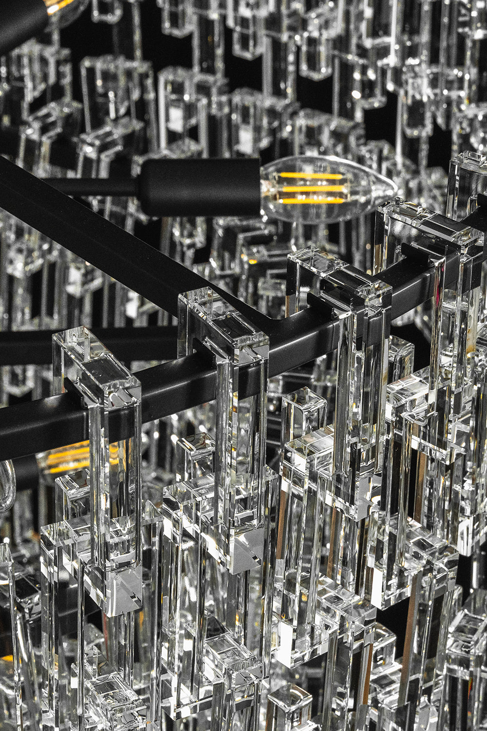 Aven Tiered Glass Prism Chandelier | Glass, Metal | Macro close-up focus on the black metal multi-tier structural frame and internal light bulb sockets | Detail shot | vexa lamps