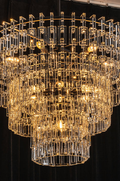 Aven Tiered Glass Prism Chandelier | Glass, Metal | Close-up studio shot of the illuminated chandelier tiers filled with sparkling warm yellow ambient light | vexa lamps
