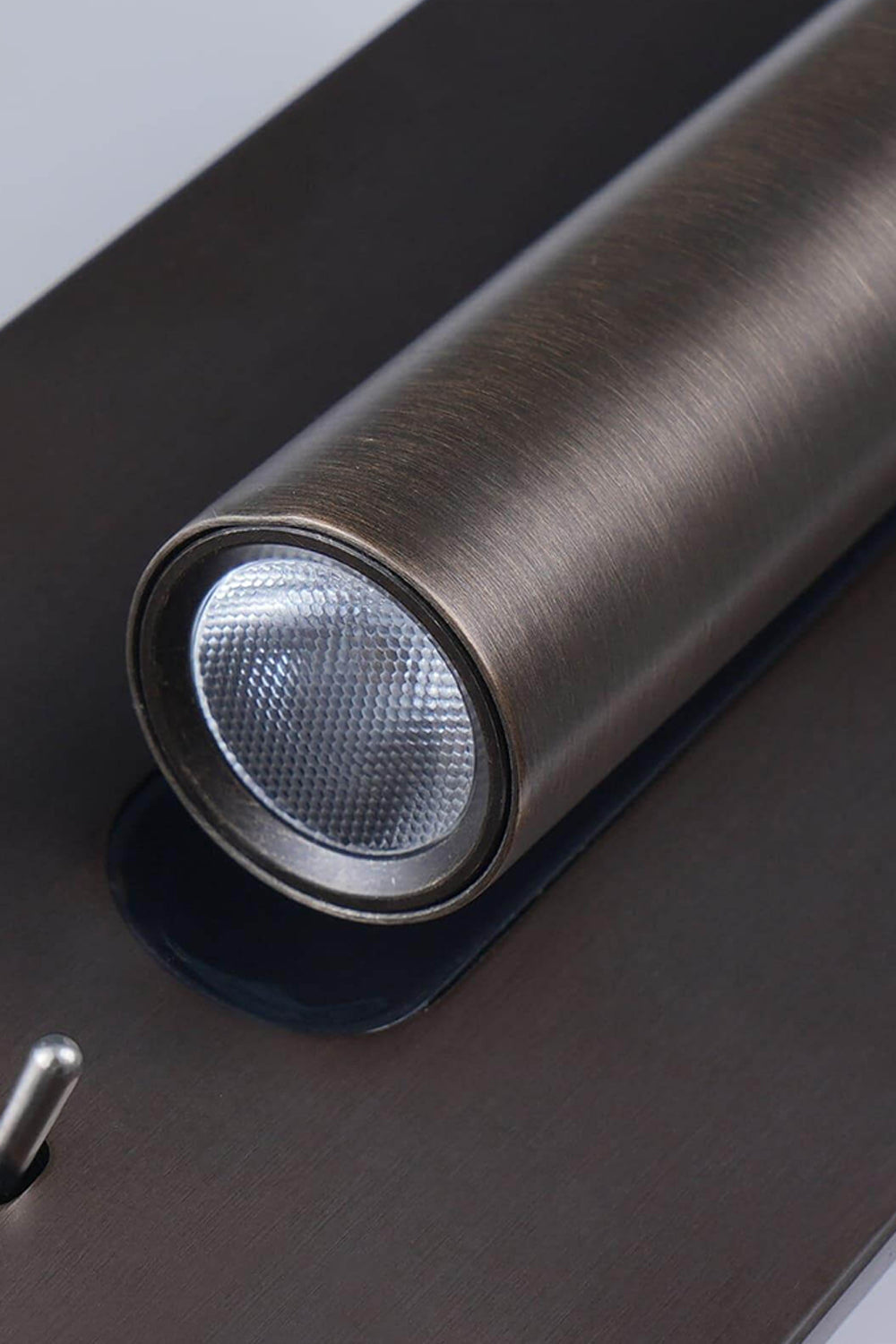 Close-up of Axial Pivot Folding LED Wall Lamp showcasing the sleek aluminum spotlight and brushed metal backplate.