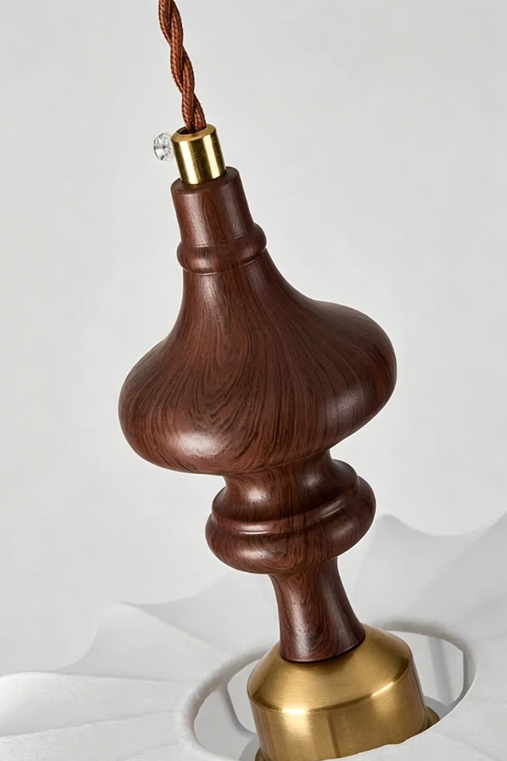 Close-up of the artisan-turned wooden spindle on the Baird Mid-Century Silk Pendant Light.