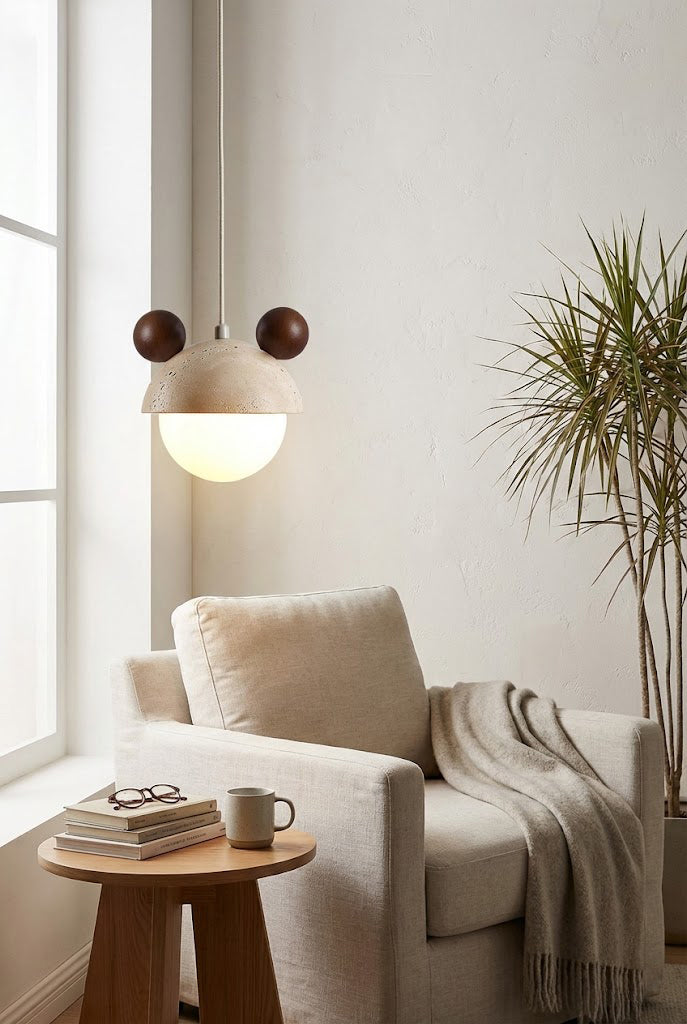 Modern bear ear pendant light in a reading corner | Travertine, Metal, Glass | Hanging near an armchair and side table | vexa lamps
