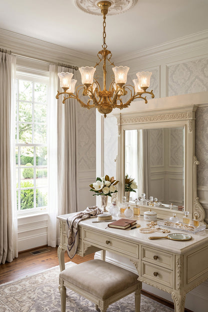 Beatrix Acanthus Leaf Chandelier | Ornate Brass and Frosted Carved Glass | Styled above an elegant white dressing vanity table with a round mirror and matching stool in a bedroom | vexa lamps