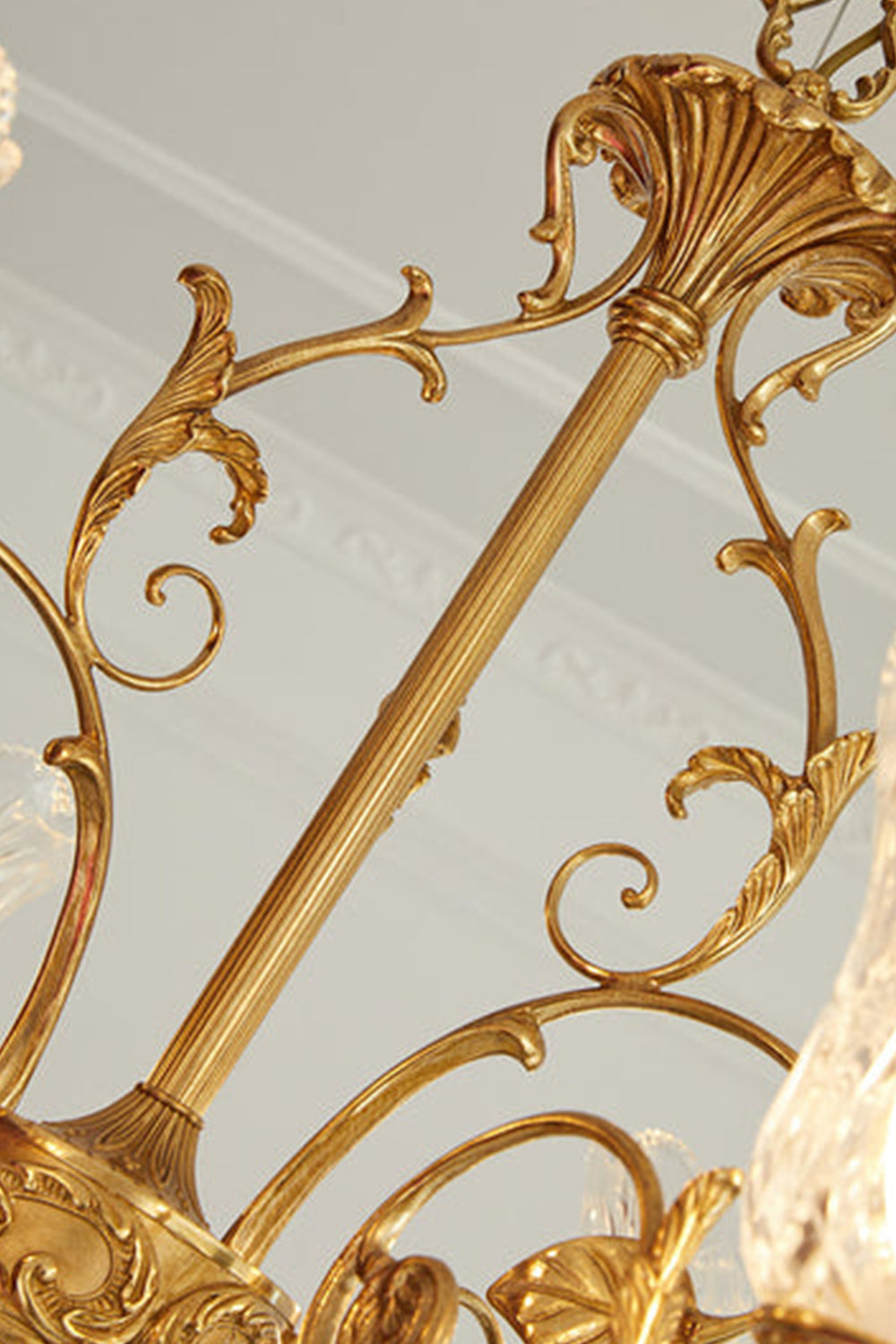 Beatrix Acanthus Leaf Chandelier | Ornate Brass and Frosted Carved Glass | Close-up view focusing on the decorative golden metal chain column decorated with delicate scrolls | vexa lamps