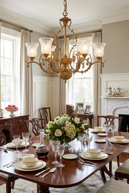 Beatrix Acanthus Leaf Chandelier | Ornate Brass and Frosted Carved Glass | Illuminating an elegant formal dining room set with a wooden table, cozy fireplace, and large windows | vexa lamps
