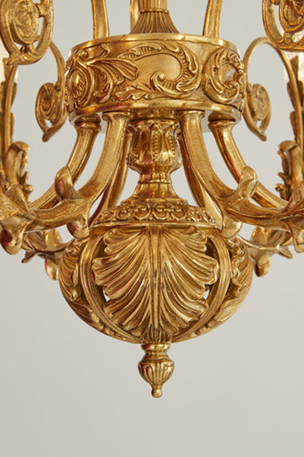 Beatrix Acanthus Leaf Chandelier | Ornate Brass and Frosted Carved Glass | Macro shot showcasing the elaborate acanthus leaf carvings on the central bottom brass ball finial | vexa lamps