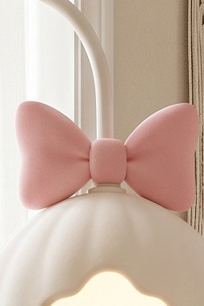 Bella Bow Arched Floor Lamp | Metal, Resin | Macro close-up focus on the cute molded pastel pink bow knot detail sitting atop the white scalloped lampshade | Detail shot | vexa lamps