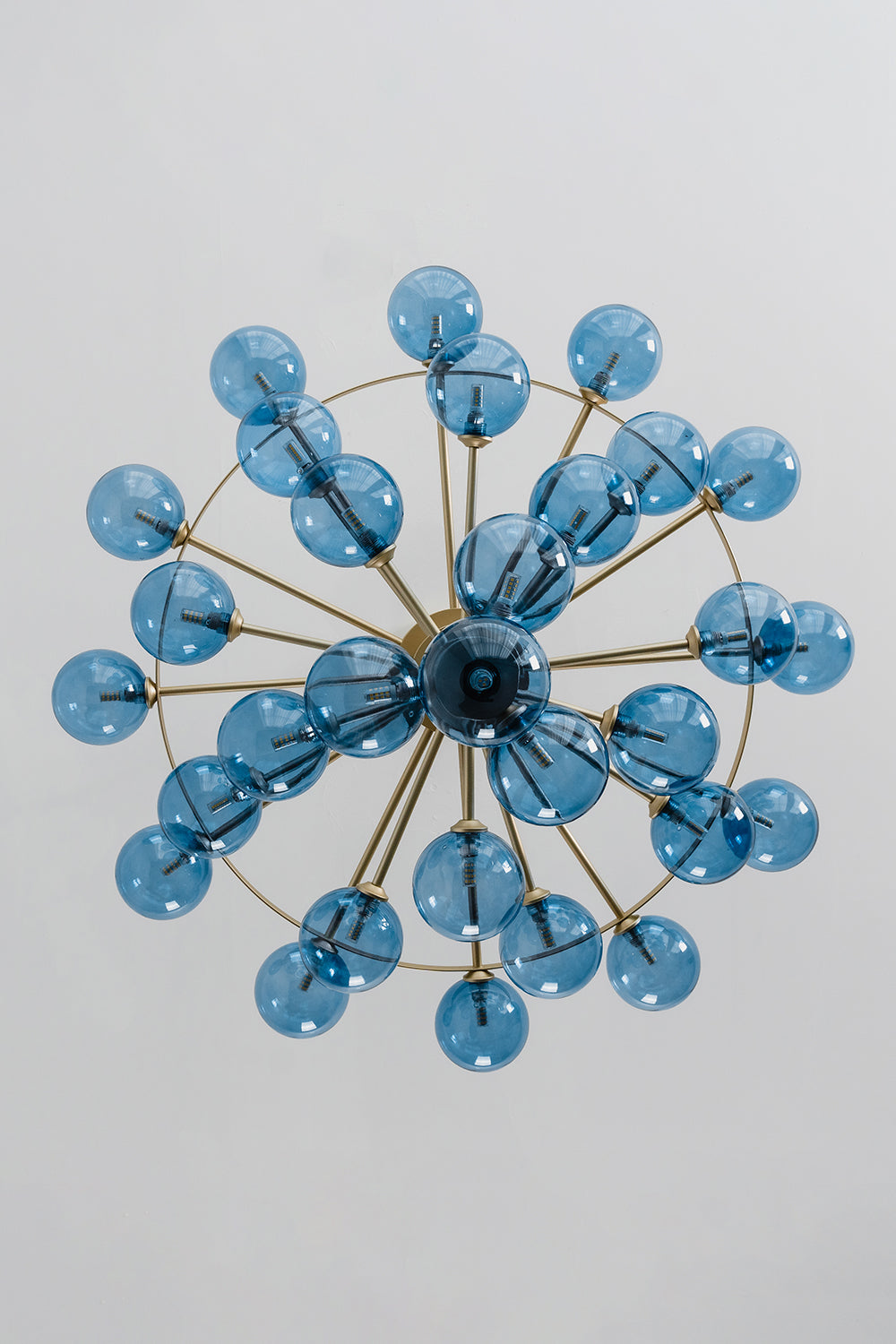 Blue Glass Bubble Globe Tiered Chandelier | Blue Glass and Brass Metal | Directly underneath bottom-up view displaying the radial starburst pattern of the blue spheres | vexa lamps