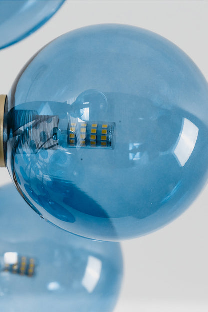 Blue Glass Bubble Globe Tiered Chandelier | Blue Glass and Brass Metal | Close-up macro detail of the vibrant blue blown glass bubbles attached to the hardware | vexa lamps