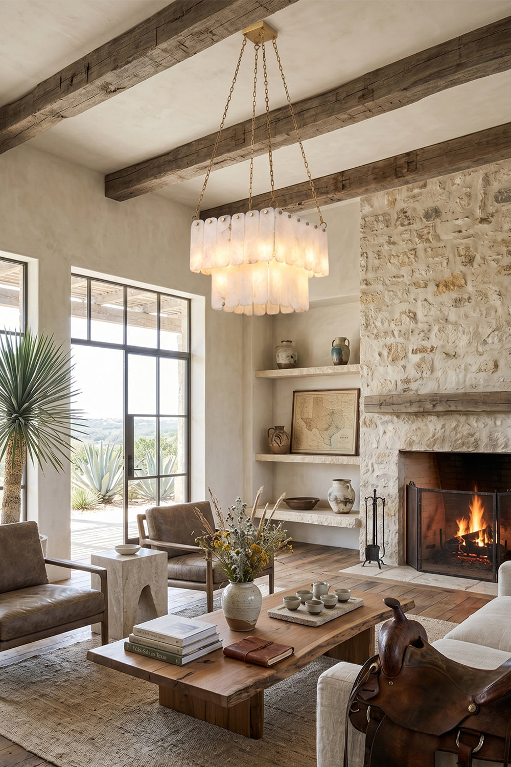 Callista Tiered Alabaster Chandelier | Alabaster, Metal | Wide-angle view of the illuminated tiered alabaster fixture in a luxurious cabin-style living room with a burning stone fireplace | vexa lamps