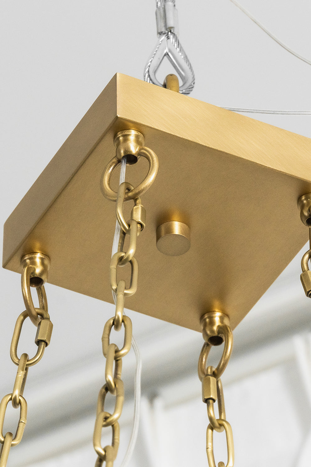 Callista Tiered Alabaster Chandelier | Alabaster, Metal | Close-up focus on the square brushed gold brass ceiling canopy plate and the heavy-duty loop ring connections with chain links | Detail shot | vexa lamps