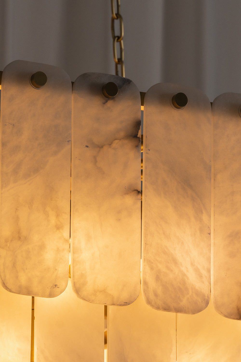 Callista Tiered Alabaster Chandelier | Alabaster, Metal | Detailed close-up view of the illuminated translucent stone tiles highlighting the rich warm light transmission and internal veining | Detail shot | vexa lamps