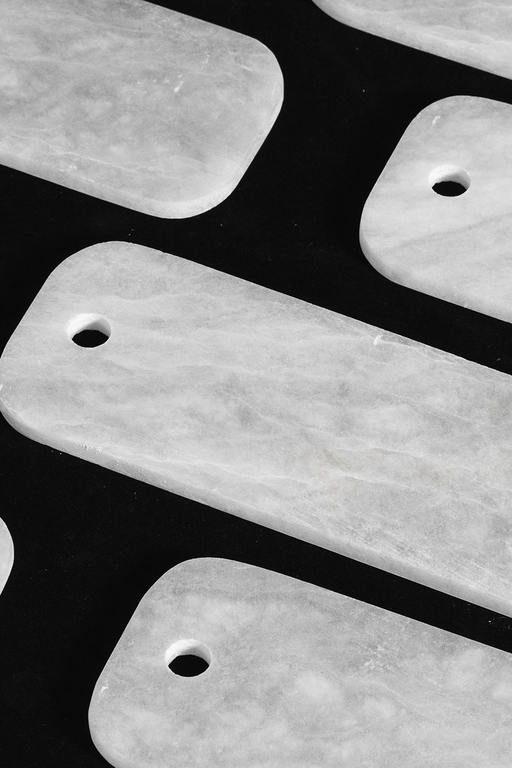 Callista Tiered Alabaster Chandelier | Alabaster, Metal | Macro close-up view of loose rectangular white alabaster stone plates showcasing their pre-drilled holes and natural mineral cloud patterns | Detail shot | vexa lamps