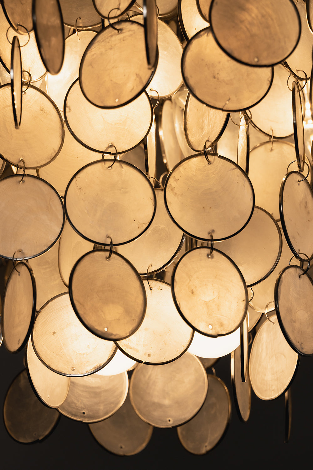 Close-up of lit natural Capiz shell discs | Shell | Detailed view of iridescent texture and metal rings | vexa lamps