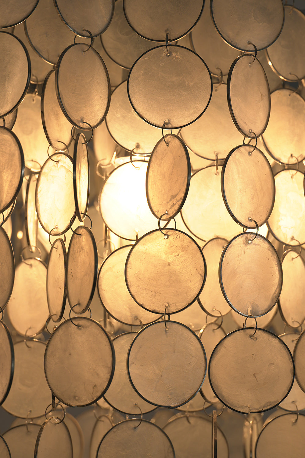 Close-up of glowing Capiz shell discs | Shell | Detail shot of warm illumination through translucent shells | vexa lamps