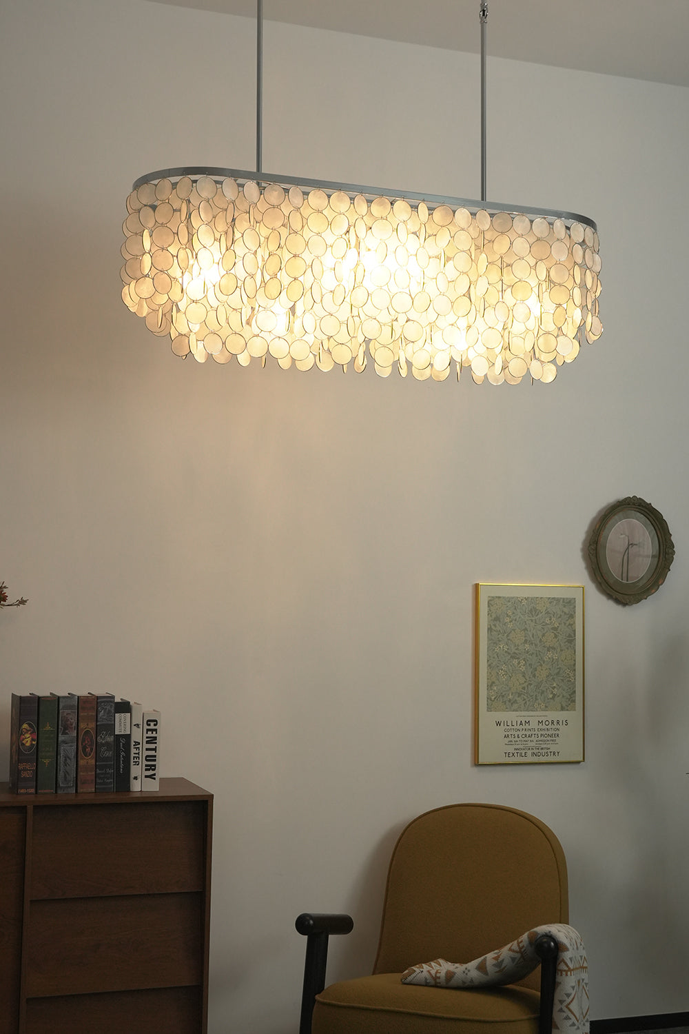 Elongated shell chandelier for workspace | Iron | Shell | Hanging in a modern corner with artwork and a yellow chair | vexa lamps