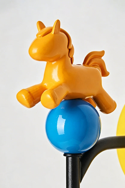Carousel Horizon Ceramic Wall Sconce | Metal, Resin, Ceramics | Macro close-up of the playful orange resin horse perched on a glossy blue sphere | Detail shot | vexa lamps